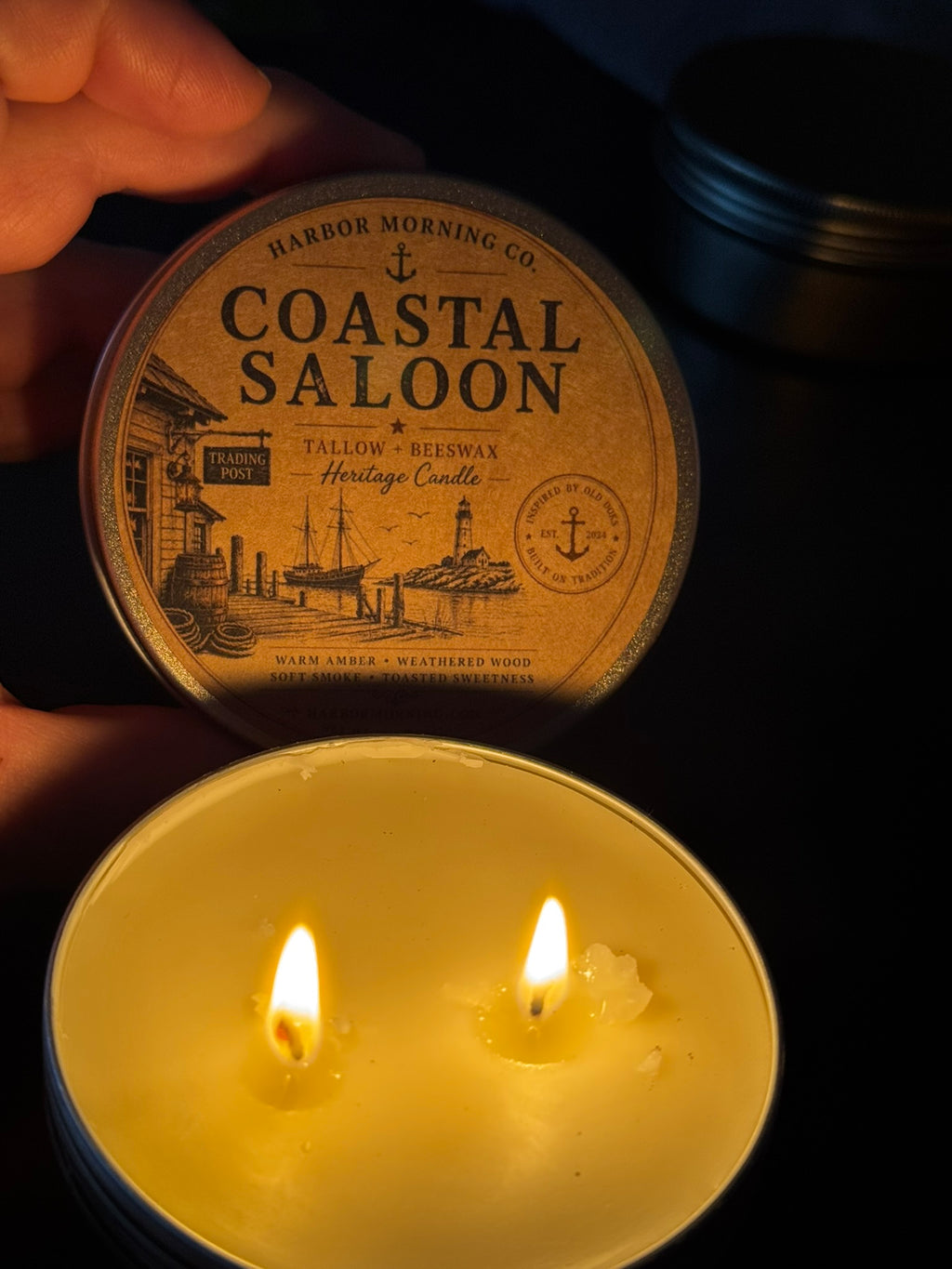 Candle with 'Coastal Saloon' packaging on a dark background
