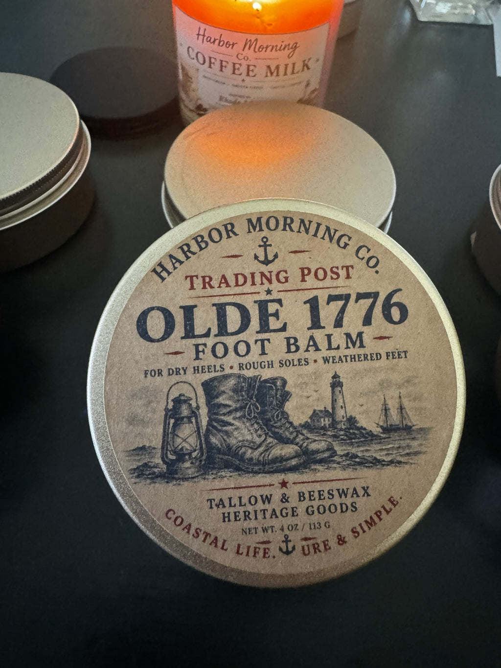 Coaster with 'Harbor Morning Co. Trading Post Olde 1776 Foot Balm' design on a dark surface.