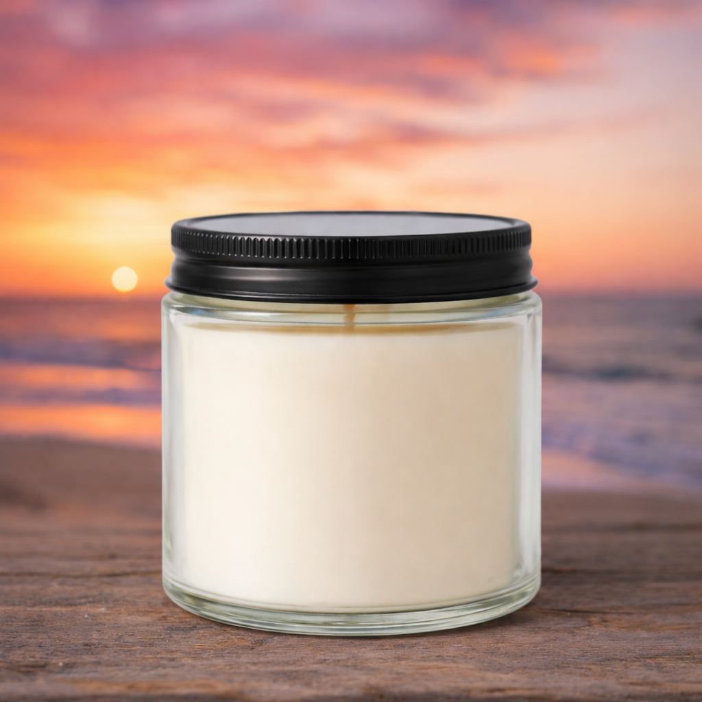 Harbor Morning Co. Beach Sunset 4oz hand-poured coastal soy candle on a wooden surface with ocean sunset in the background