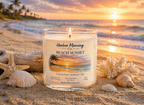 Harbor Morning Co. Beach Sunset 8oz hand-poured coastal soy candle lit on the beach with seashells, palm trees, and tropical ocean sunset in the background